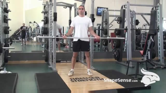 An image of a man performing the wide grip barbell curl exercise.