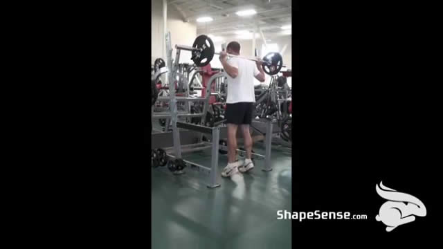 An image of a man performing the barbell calf raise exercise.