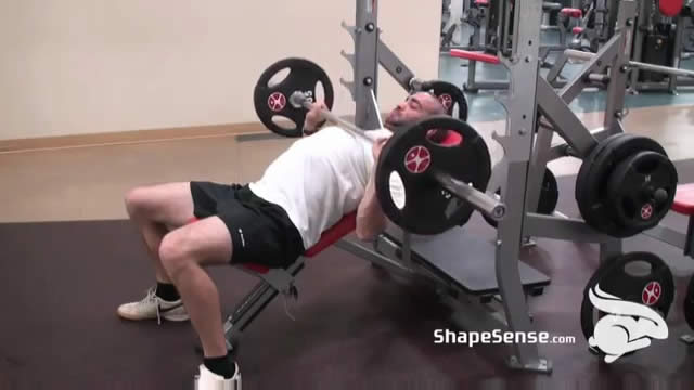 An image of a man performing the incline bench press exercise.