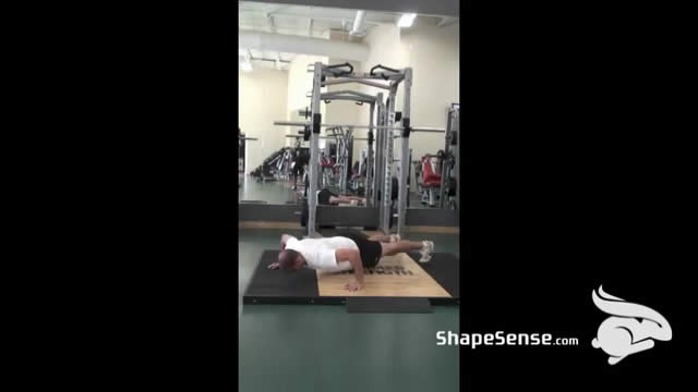 An image of a man performing the wide grip push up exercise.