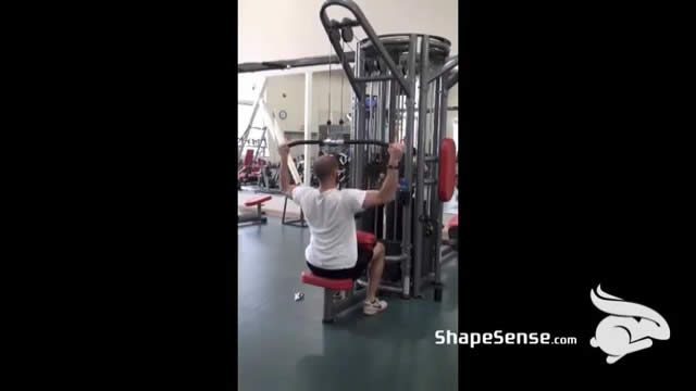 An image of a man performing the lat pull down exercise.