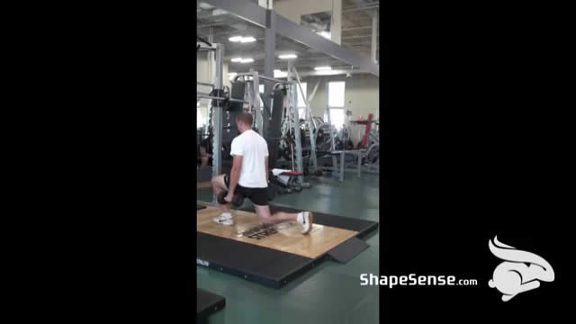 An image of a man performing the dumbbell lunge exercise.