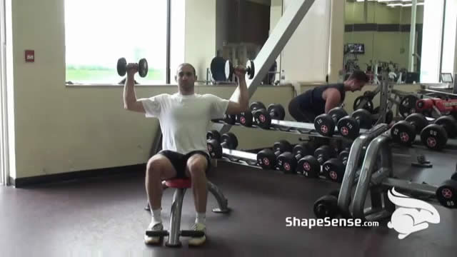 An image of a man performing the dumbbell shoulder press exercise.