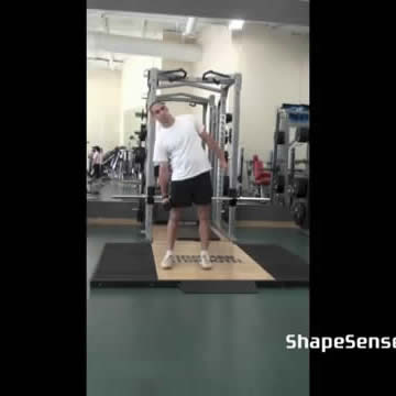 An image of a man performing the dumbbell side bend exercise.