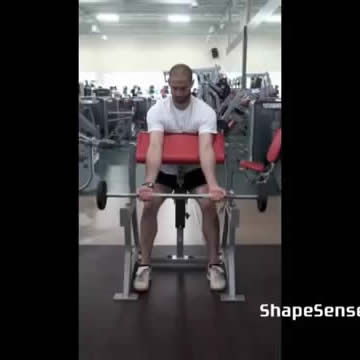 An image of a man performing the barbell preacher curl exercise.