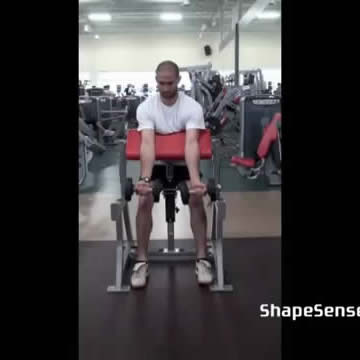 An image of a man performing the dumbbell preacher curl exercise.