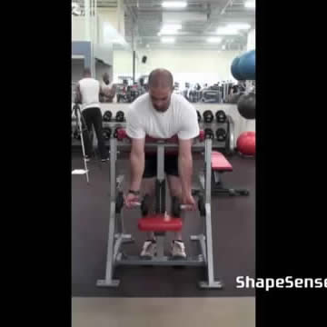 An image of a man performing the spider curl exercise.