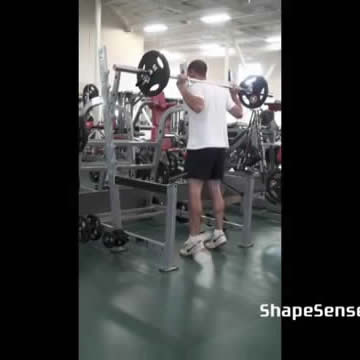 An image of a man performing the barbell calf raise exercise.