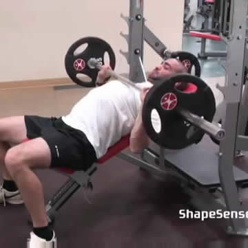 An image of a man performing the incline bench press exercise.