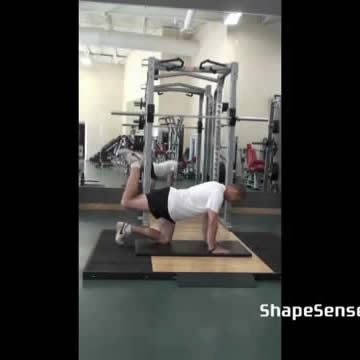 An image of a man performing the glute kickback (donkey kick) exercise.