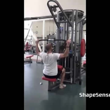 An image of a man performing the lat pull down exercise.