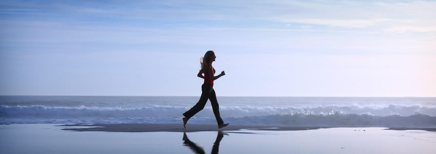 A woman jogging on the beach.