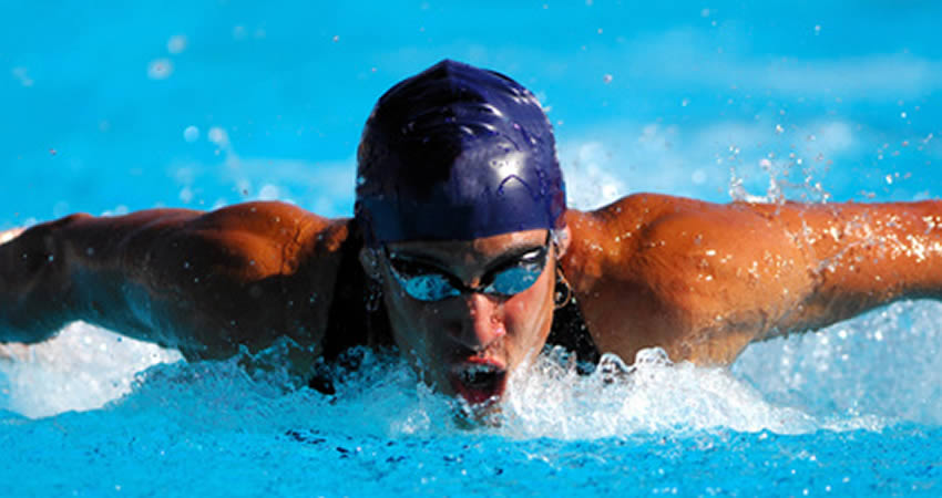 A fit man swimming butterfly stroke.