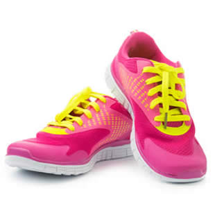 A pair of pink running shoes with yellow laces.