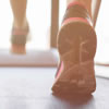 A pair of feet walking on a treadmill.