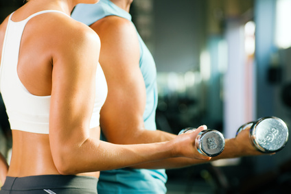 a man and a woman doing dumbell curls